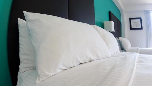 a white bed with white pillows on top of it at Hotel Santa Fe in Tlatlauquitepec