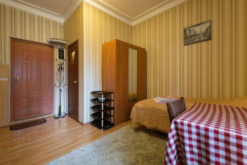 a bedroom with a bed and a table and a door at Apartment Nadezhda at Kabanbay Batyr 122 in Almaty
