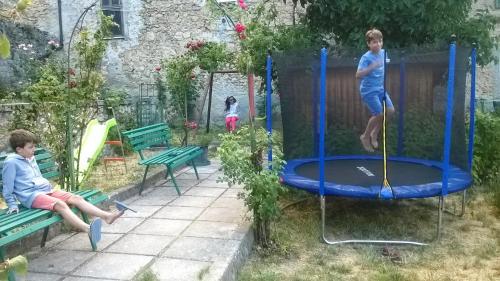 two children playing on a trampoline in a yard at Grotta dei Colombi in Scanno