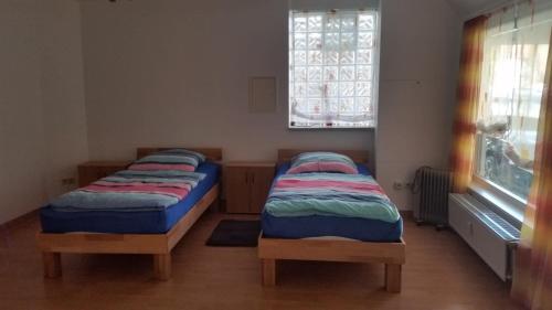two beds sitting in a room with a window at Baunaeck in Baunatal