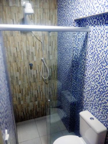 a bathroom with a glass shower with a toilet at Pousada Itararé in Campina Grande
