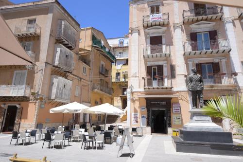 a statue in front of a building with chairs and umbrellas at B&B Empedocle in Porto Empedocle