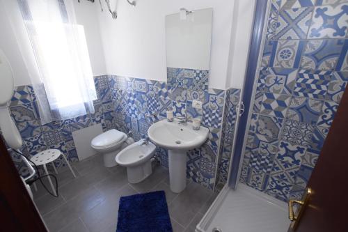 a blue and white bathroom with a sink and a toilet at B&B Empedocle in Porto Empedocle