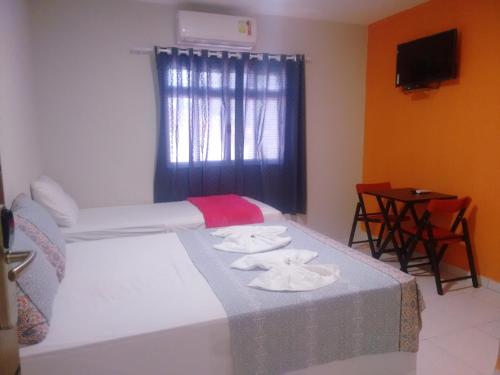 a bedroom with a bed with two towels on it at Pousada Itararé in Campina Grande