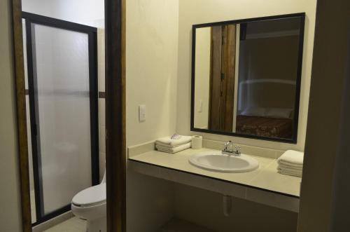 y baño con lavabo, aseo y espejo. en Villa Meztli en San Juan Teotihuacán