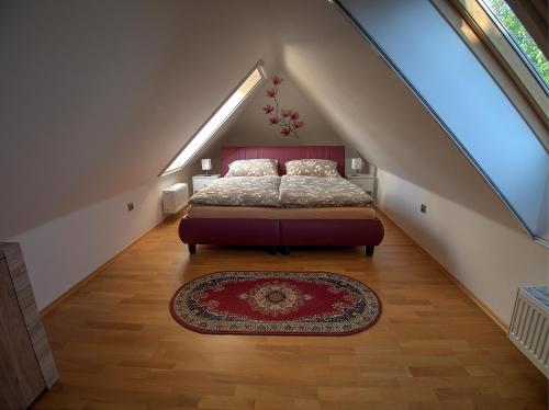 a attic bedroom with a bed and a rug at Vila Veronika in Lednice