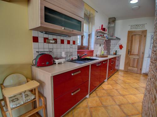 a kitchen with red cabinets and a counter top at Vila Veronika in Lednice