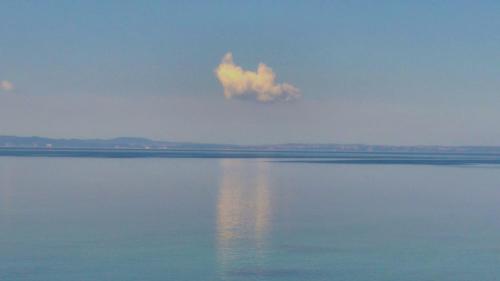 a cloud in the sky over a large body of water at To Spitaki in Neos Marmaras
