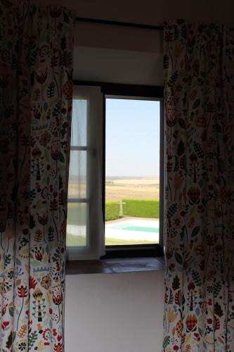 a window in a room with a view of a field at Monte Da Morena Agro-Turismo in Serpa
