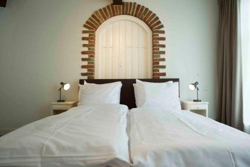 a bedroom with two beds with white sheets at Logement 't Oude Bierhuys in Middelburg