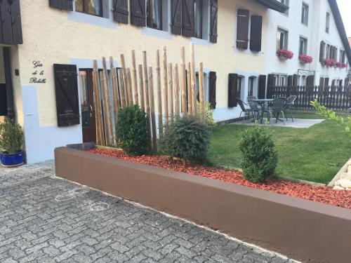 a fence in front of a building with a patio at Gite de la Robella in Buttes