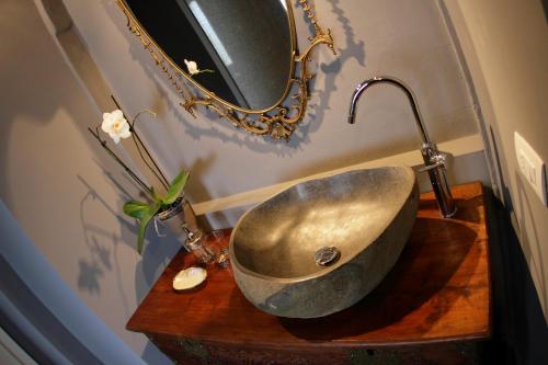 a bathroom with a stone sink and a mirror at Casa Galante in Cividale del Friuli