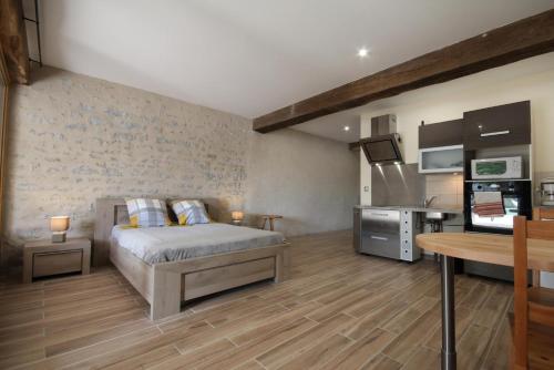 a bedroom with a bed and a kitchen in a room at Au Foudre du bazois in Châtillon-en-Bazois