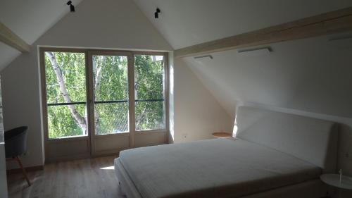 a bedroom with a bed and a large window at Rest Apartment Preila in Preila