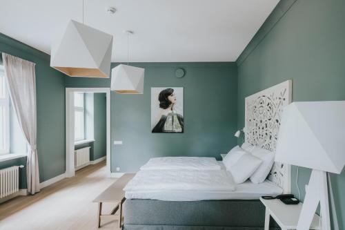 a bedroom with green walls and a bed and a table at Villa Santa in Cēsis