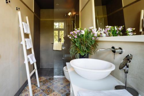 a bathroom with a sink and a toilet and flowers at Villa Santa in Cēsis