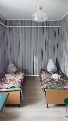 Habitación con 2 camas y lámpara de araña. en Glamour Hotel en Luhyny