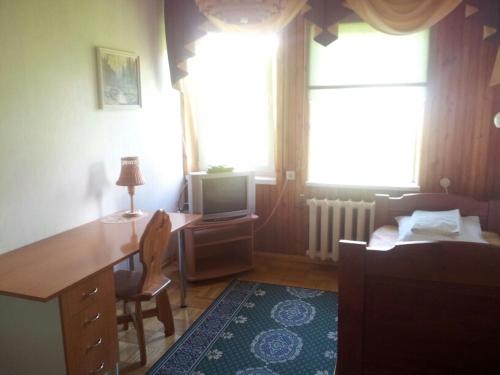 a bedroom with a desk and a bed and a television at Eha Suija Home Accommodation in Tartu