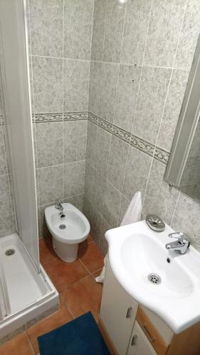 a bathroom with a sink and a toilet at Casa Conil Cruz in Conil de la Frontera