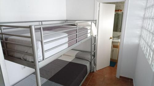 a bunk bed in a small room with a staircase at Casa Conil Cruz in Conil de la Frontera