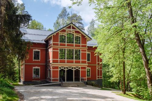 a red house with trees in front of it at Villa Santa in Cēsis