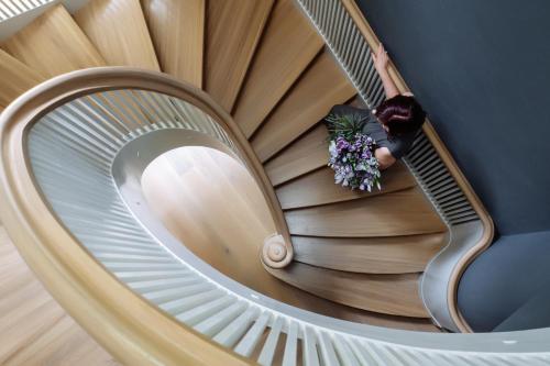 a spiral staircase with a person holding a bouquet of flowers at Villa Santa in Cēsis