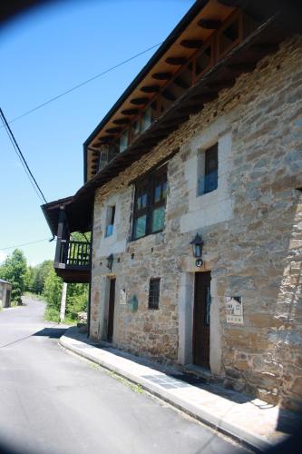 a stone building with a balcony on the side of it at Alojamiento Luz de Hadas in Sampil