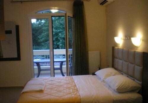 - une chambre avec un lit et une vue sur une terrasse dans l'établissement Royal's Studios, à Loutra Edipsou