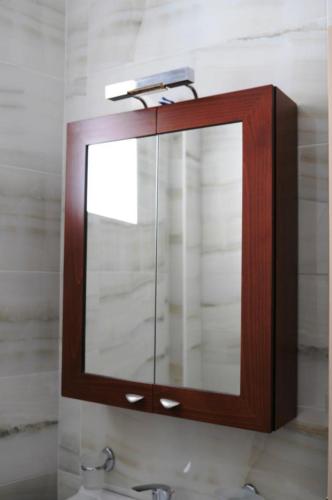 a mirror on a wall above a bathroom sink at Royal's Studios in Loutra Edipsou