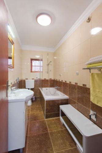 a bathroom with a tub and a sink and a bath tub at Apartman Ana in Skradin