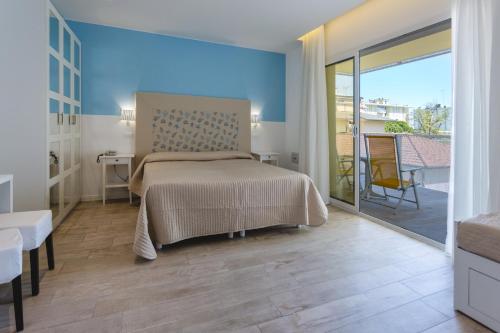 a bedroom with a bed and a sliding glass door at Hotel Speranza in Lido di Jesolo