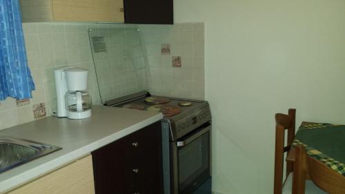 a kitchen with a stove top oven next to a counter at Eva Apartments in Svoronata