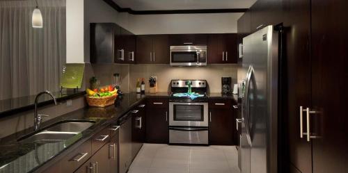 a kitchen with wooden cabinets and stainless steel appliances at Best in Jaco Condos at Diamante del Sol in Jacó