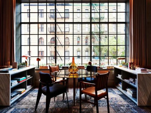 a dining room with a table and chairs and a large window at SIXTY SoHo in New York