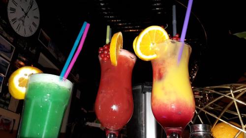 three cocktails sitting on top of a bar at Apartments Paris in Umag