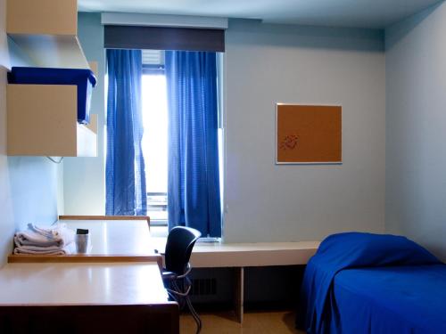 1 dormitorio con escritorio, 1 cama y ventana en Mount Saint Vincent University en Halifax