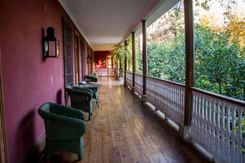 a hallway with chairs and tables on a balcony at Hacienda los Lingues Chile Valle de Colchagua in Los Lingues