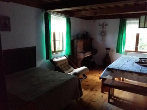 una camera da letto con tende verdi e un letto e una sedia di Dom Letniskowy Wakacje Pod Strzechą a Markocin