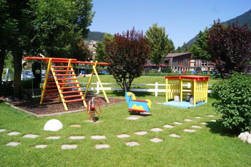 een speeltuin met speeltoestellen in een park bij Garden Hotel Bellariva in Molveno