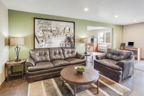 a living room with a couch and a table at Super 8 by Wyndham Grayling in Grayling