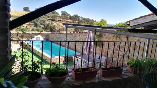 balcone con piante in vaso e piscina di Vivienda Turística Alojamiento Rural EL Trillo a El Alcornocal