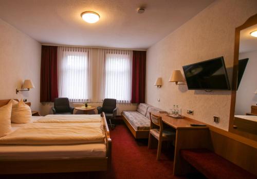 pokój hotelowy z łóżkiem i kanapą w obiekcie Hotel & Restaurant Druidenstein w mieście Trautenstein