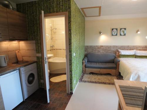a bedroom with a bed and a bathroom with a tub at Apartments Ąžuolas in Palanga