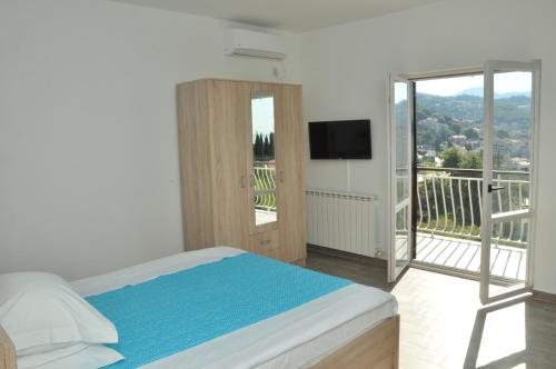 1 dormitorio con 1 cama y balcón con TV en Apartments La Dolce Vita, en Herceg-Novi