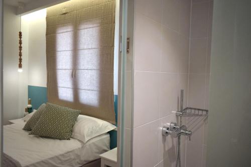 a bedroom with a bed and a shower with a mirror at Meltemi in Skiathos Town