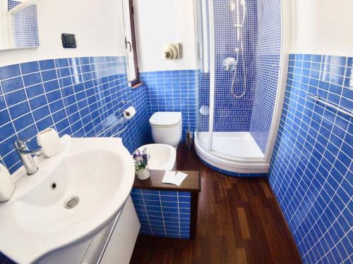 シラクーサにあるMythos Affittacamereの青いタイル張りのバスルーム(洗面台、トイレ付)