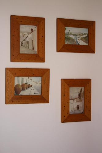 four pictures in wooden frames on a wall at Monte Da Morena Agro-Turismo in Serpa
