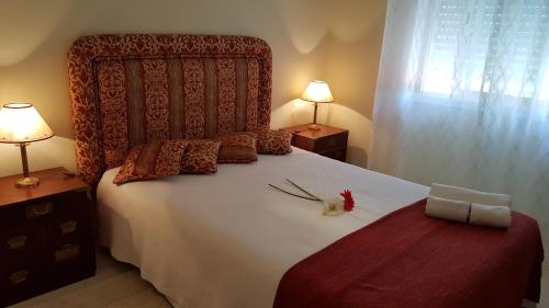 ein Schlafzimmer mit einem großen Bett mit Blumen darauf in der Unterkunft Villa Mucifal A in Sintra