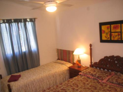a bedroom with two beds next to a window at Cabañas Rosales de Punilla in Huerta Grande