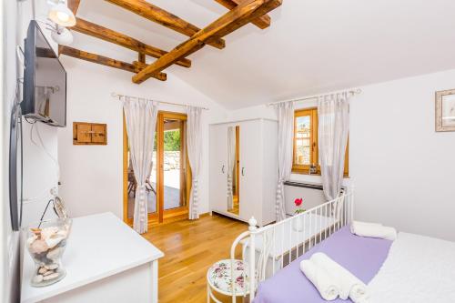 a bedroom with a white crib and wooden ceilings at Holiday house Hojevica - Kras, Krk in Kras
